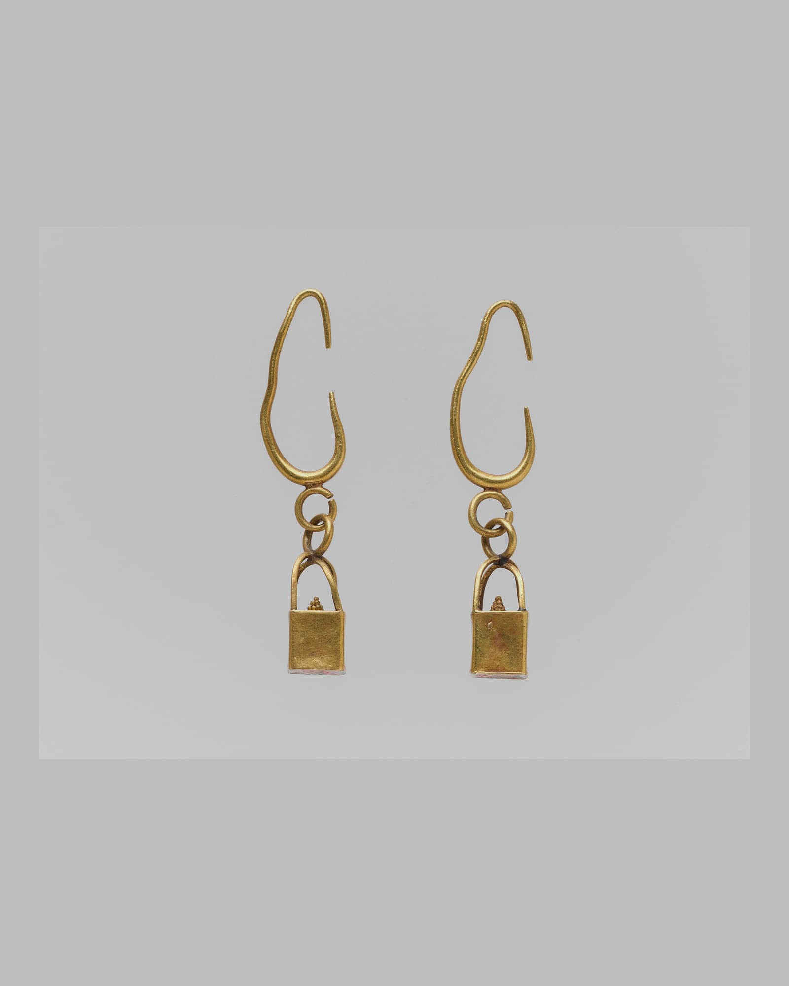 Pair of fine yellow-gold drop earrings, pale grey background