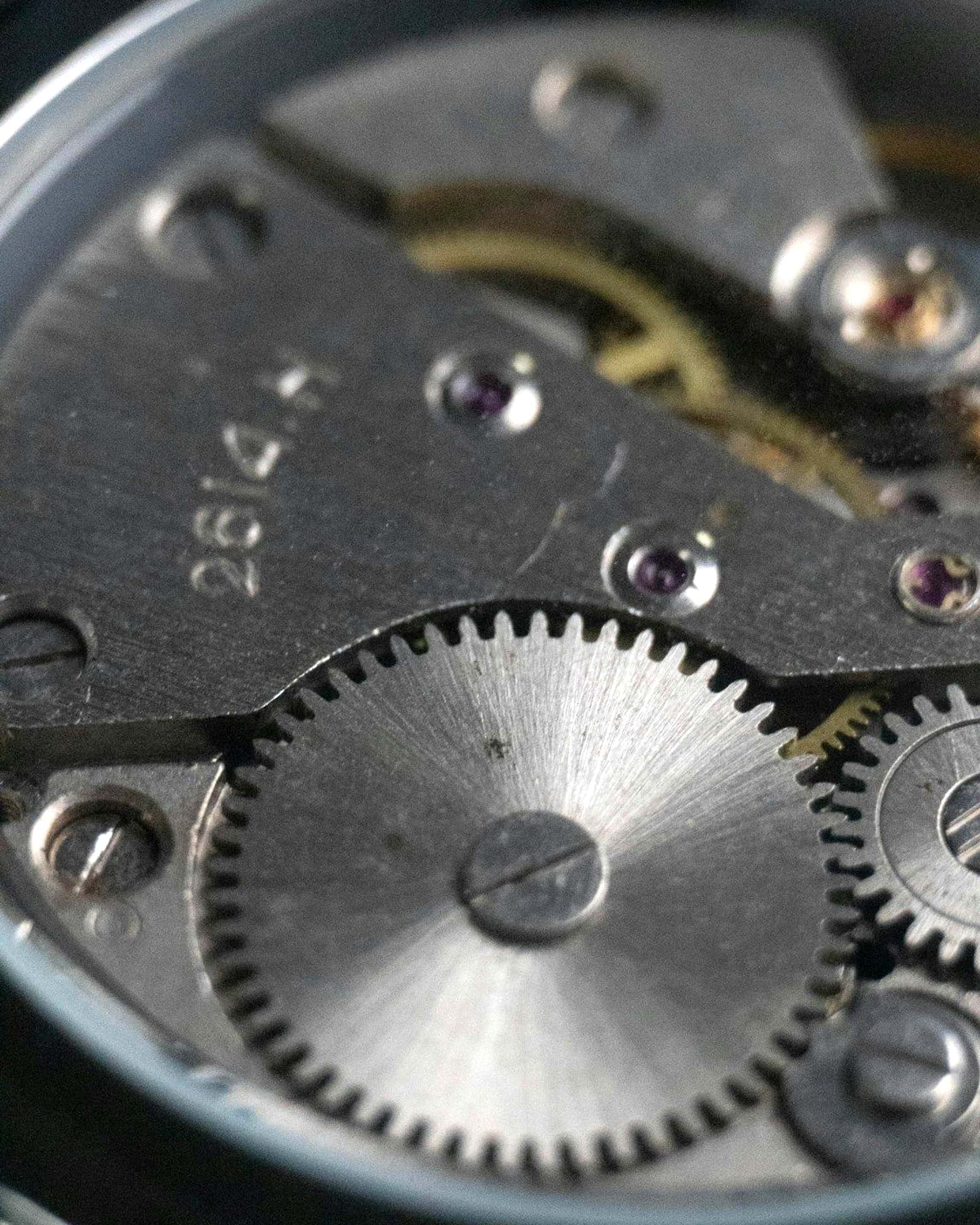 Macro view of a mechanical watch movement, gears and bridges in steel — detail view