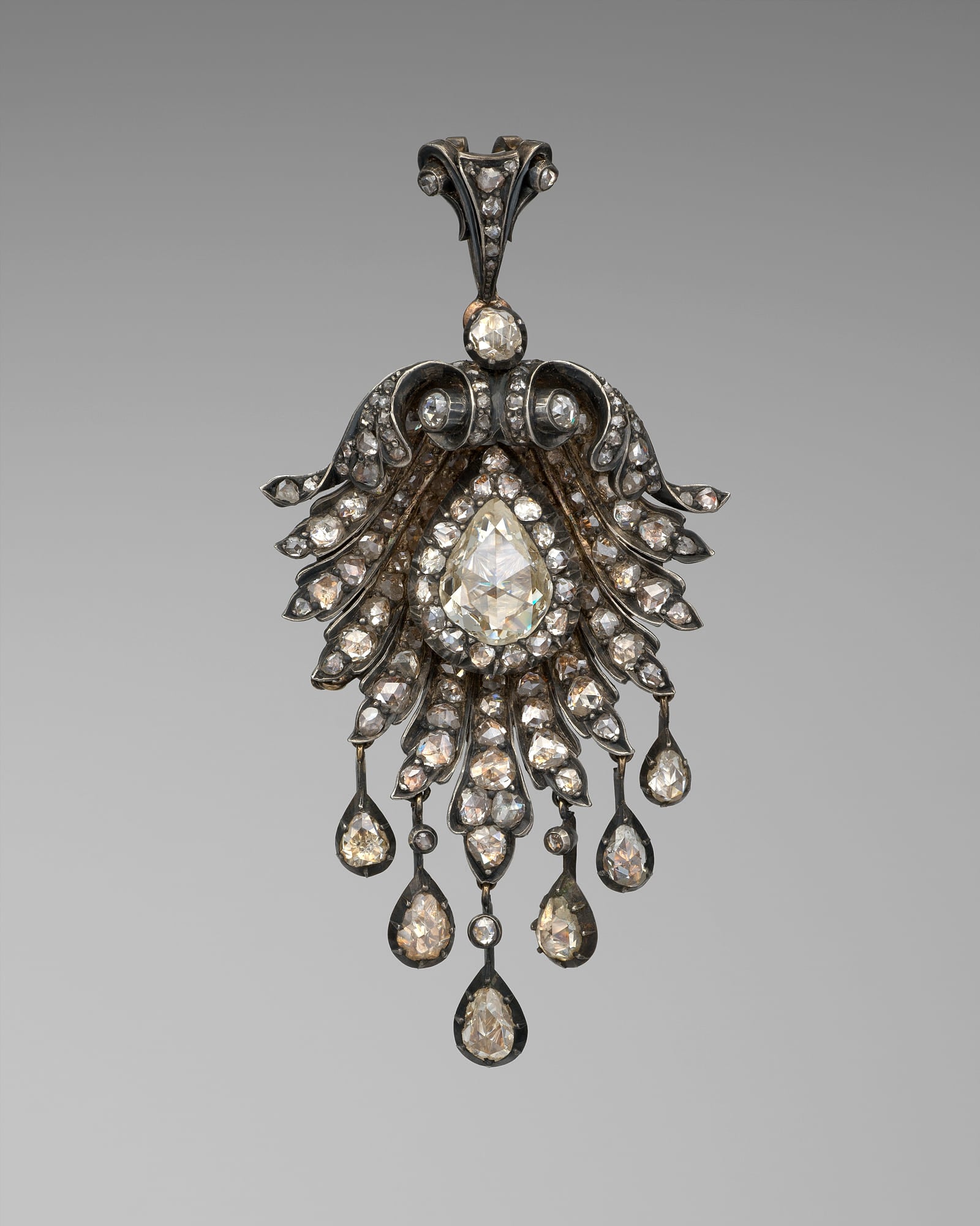 Diamond girandole pendant with drop stones, grey background — detail view