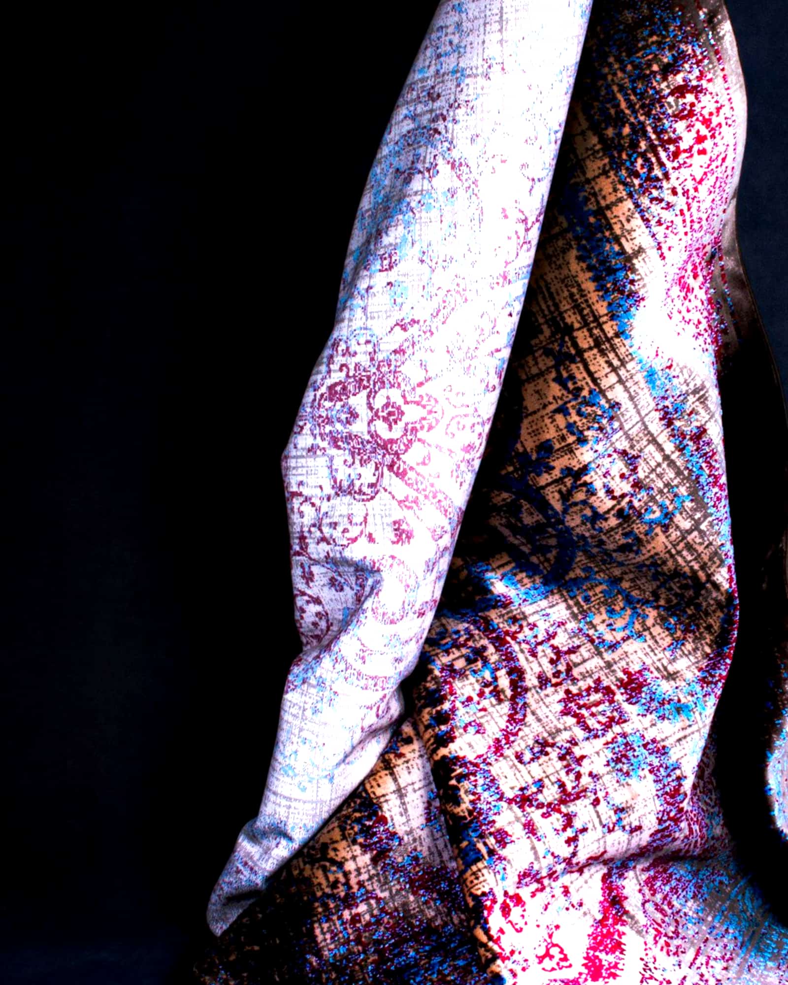 Lilac and slate paisley silk scarf draped over a dark ground — detail view