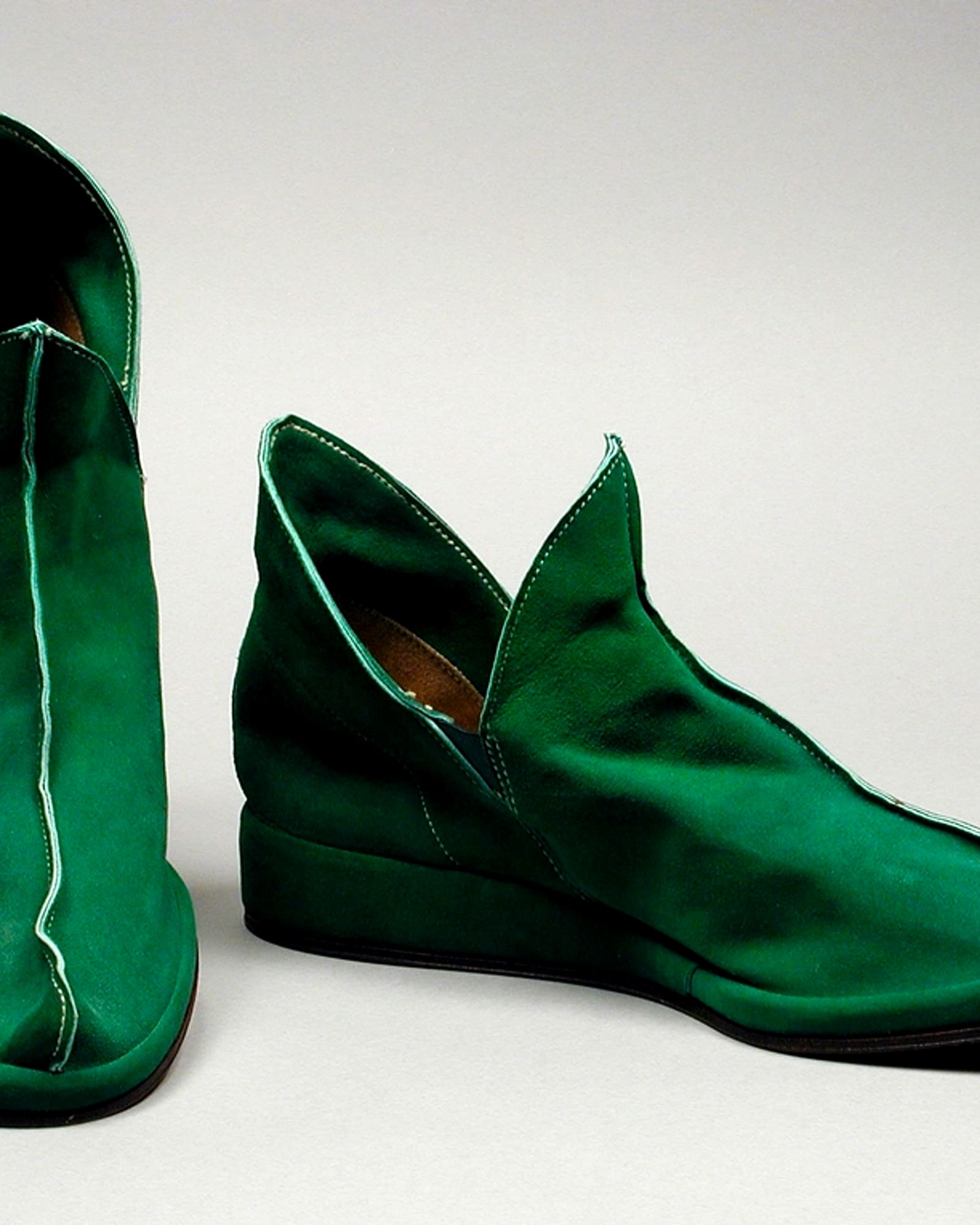 Pair of emerald satin ankle boots, white background — detail view