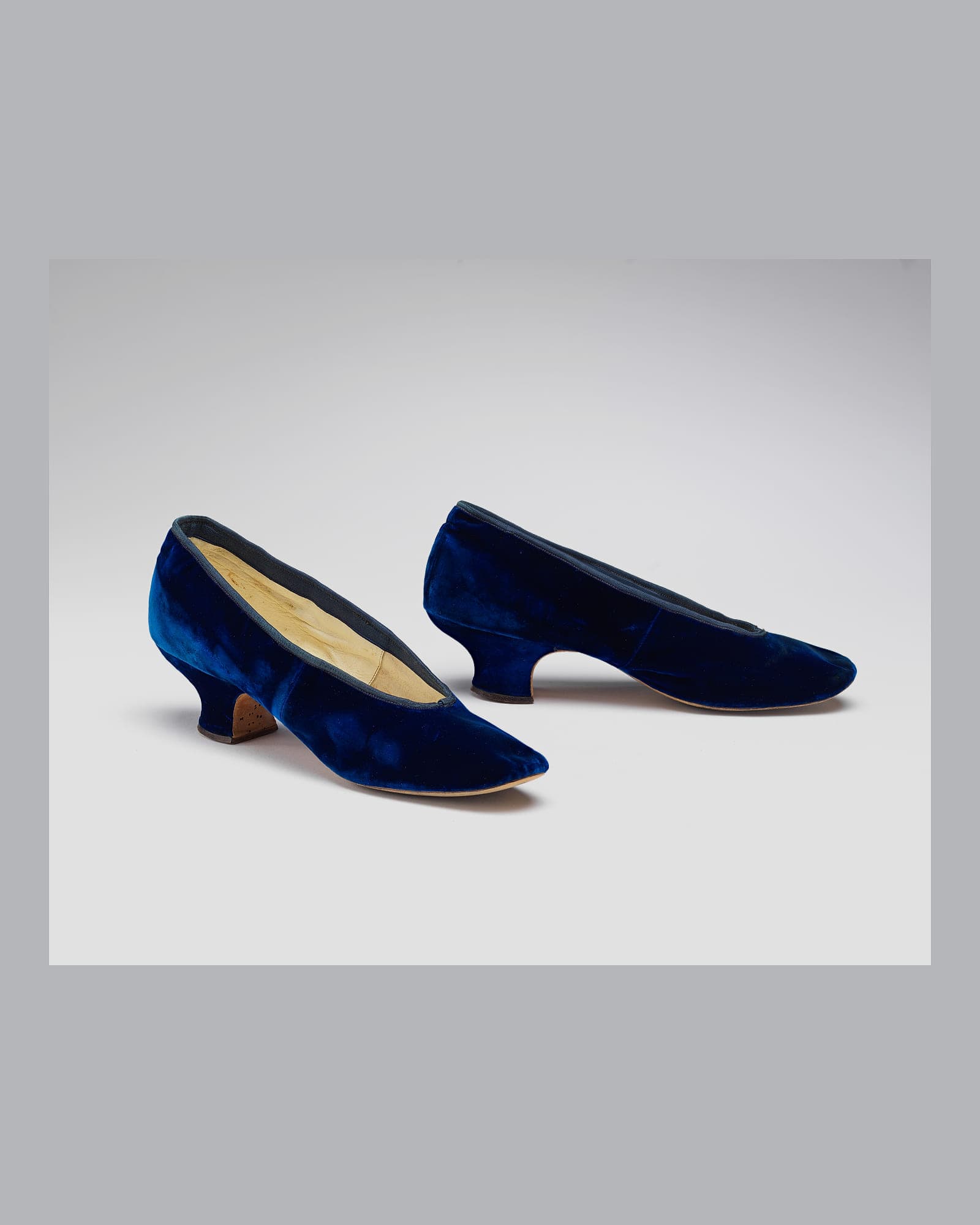 Pair of navy velvet flats, pale grey background